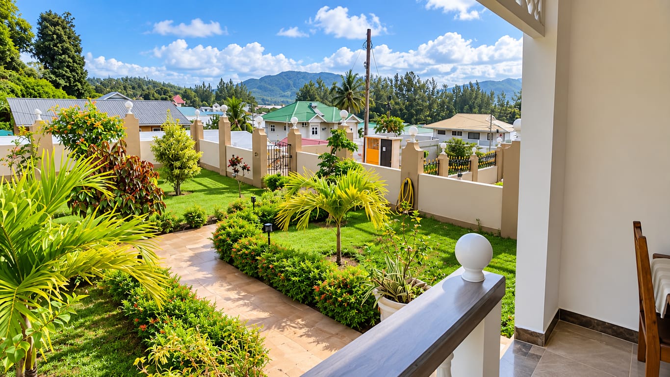 View from a balcony over the garden's lawn and palms towards wooded hills.